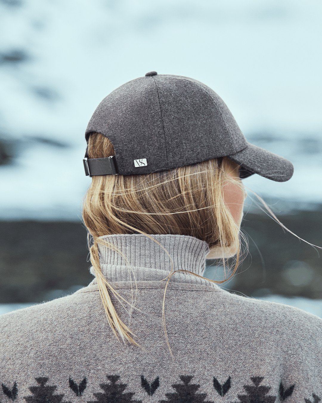 Back view of taupe brown wool cap from varsity headwear on female model in winter environment