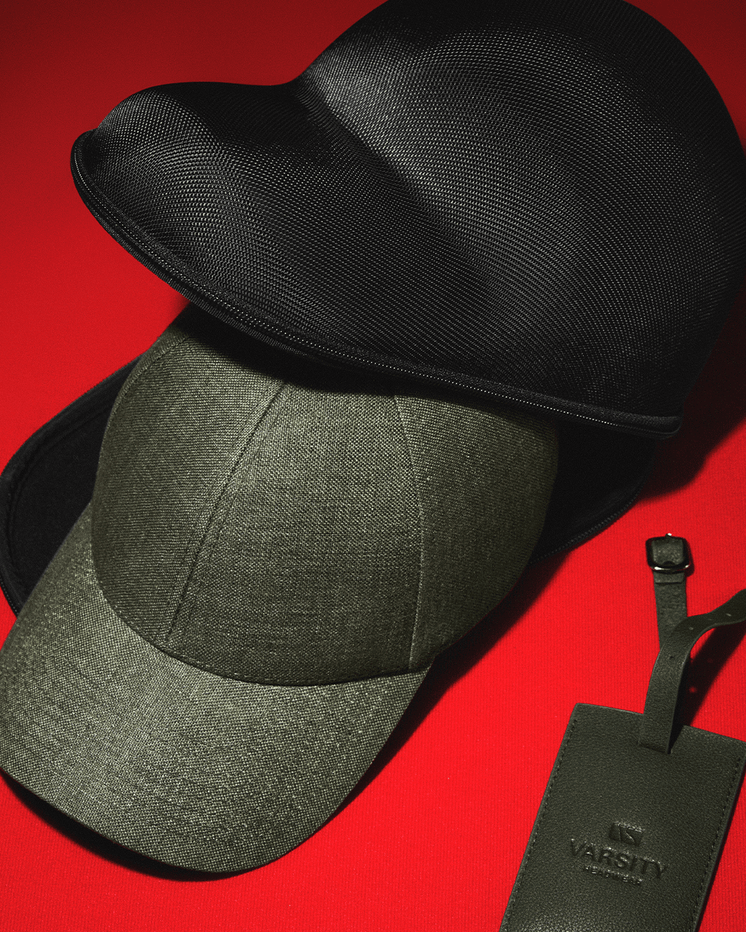Gift set for the traveller including a green linen cap, green luggage tag in leather and black travel case
