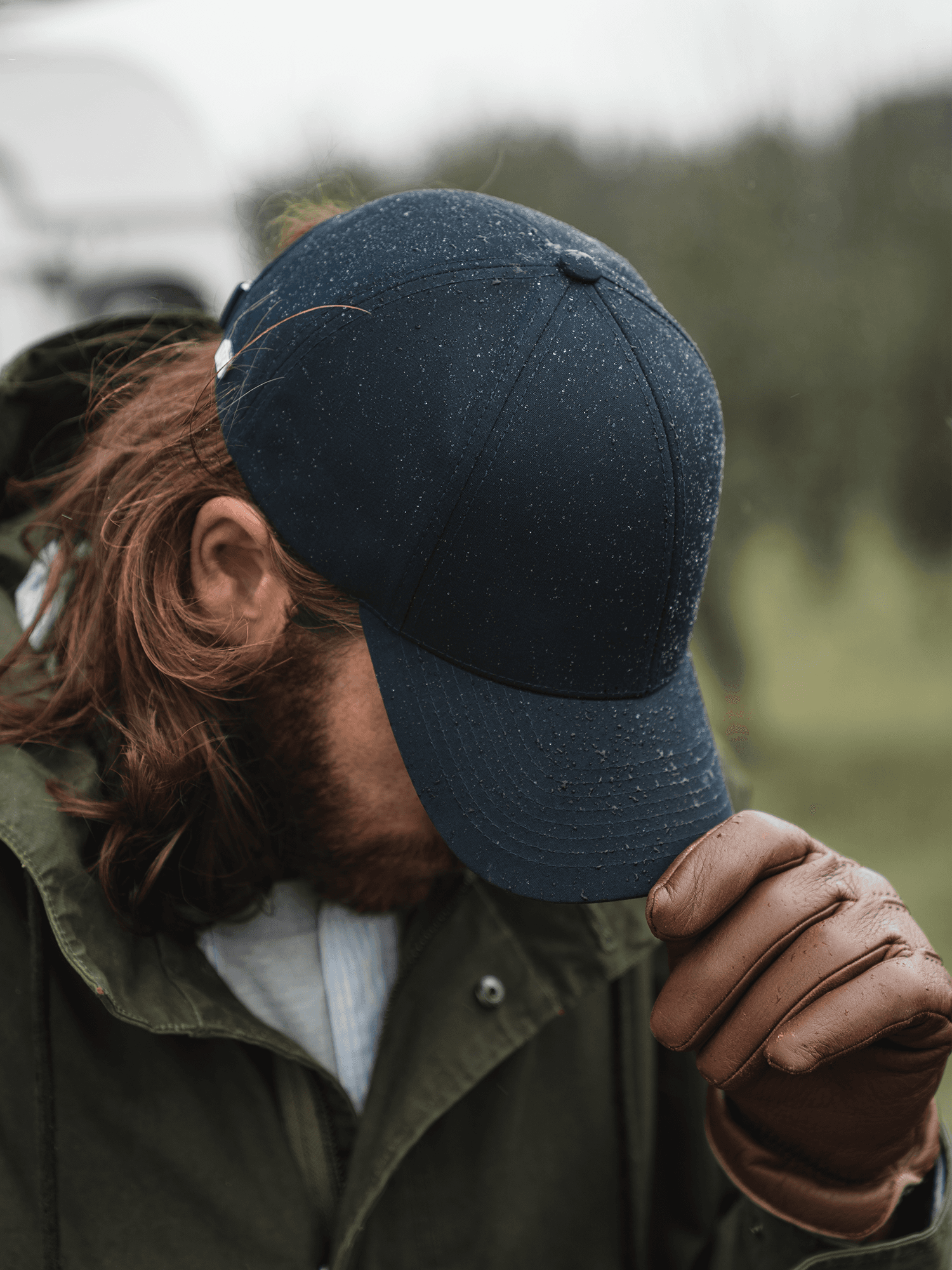 Side view of a dark navy varsity headwear cap in rain