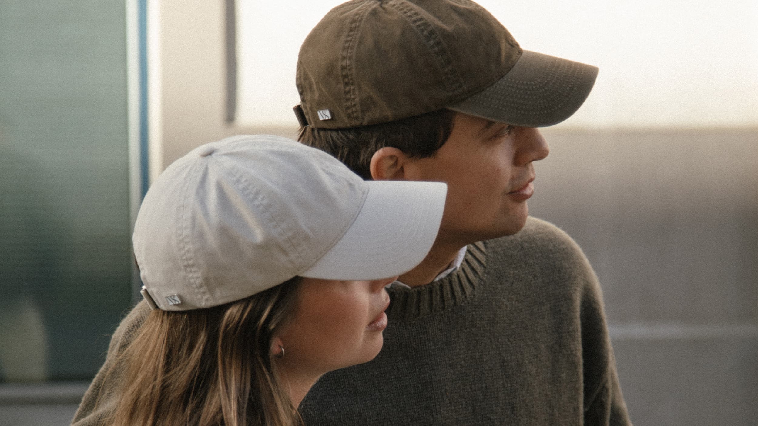Side view of male and female wearing washed cotton caps